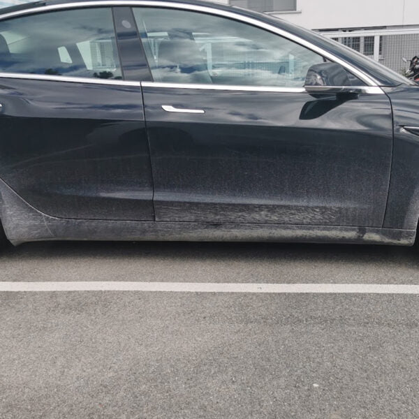 Sort Tesla Model 3 set fra siden