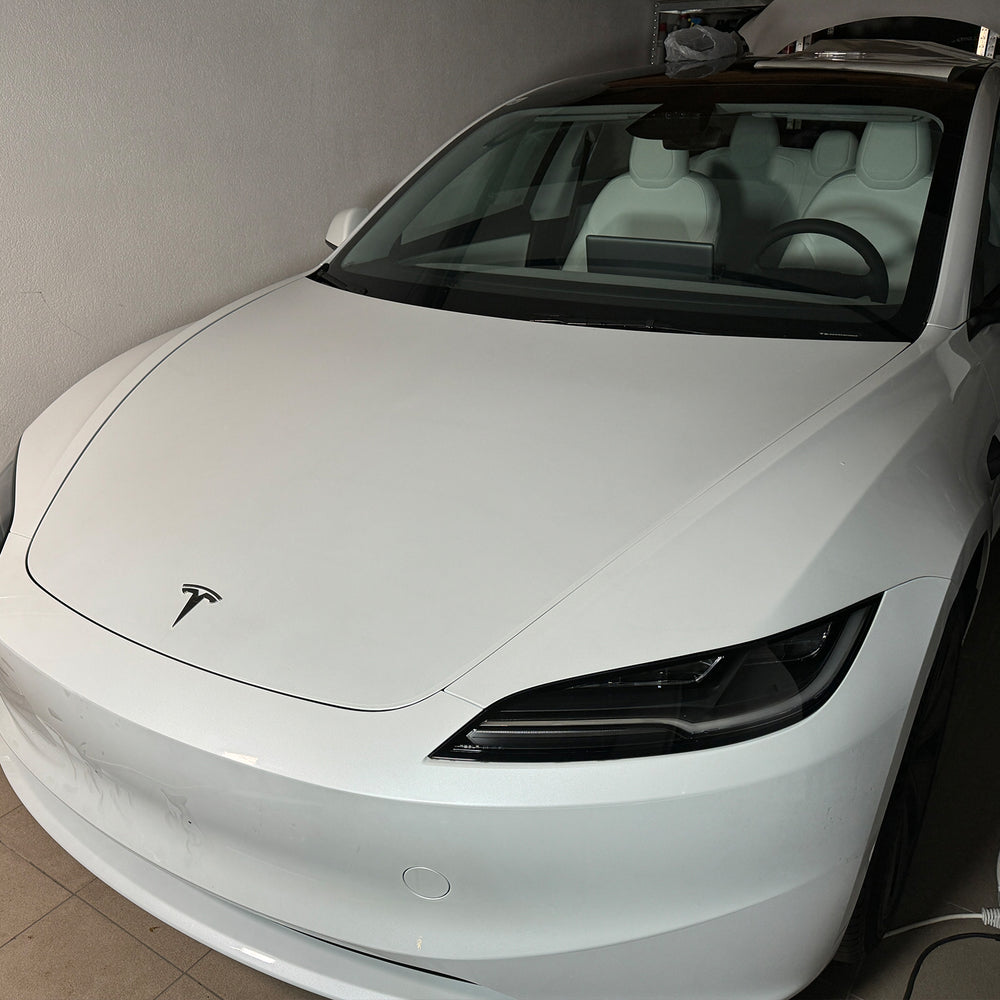 Hvid Tesla Model 3 „Highland“ set forfra i værkstedet